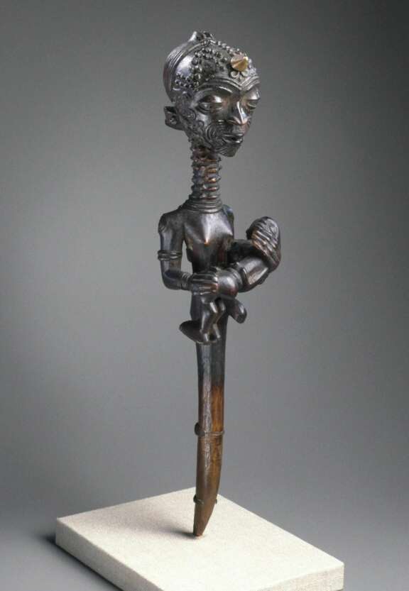Luluwa artist. Figure of a Mother Holding a Child (Lupingu lwa Cibola), 19th century. Ndemba, West Kasai Province, Democratic Republic of the Congo. Wood, copper alloy, palm oil, tukula, organic materials, 14 x 3 3/8 x 3 1/2 in. (35.6 x 8.6 x 8.9 cm). Brooklyn Museum, Museum Collection Fund, 50.124