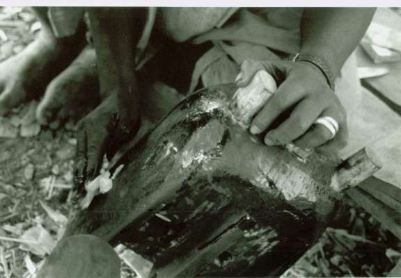 Basi Fane applying shea butter to the surface of a mask, previously blackened in the fire. © Courtesy of Professor Sarah Brett-Smith
