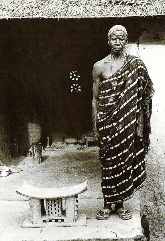 Le chef de Kongounou posant à côté d’un tabouret à cinq pieds de style akan, région Aitu, 1978 © Susan Mullin Vogel