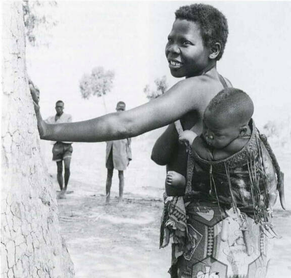 Femme dowayo portant son enfant dans un porte-bébé. Photographie de Klaus Stuttgart. S.d. Voir KRÜGER Christoph, "Dowayo : Namchi Puppen aus Kamerun Die Dowayo und ihr Kult", Düsseldorf, Verlag U. Gottschalk, 2003.