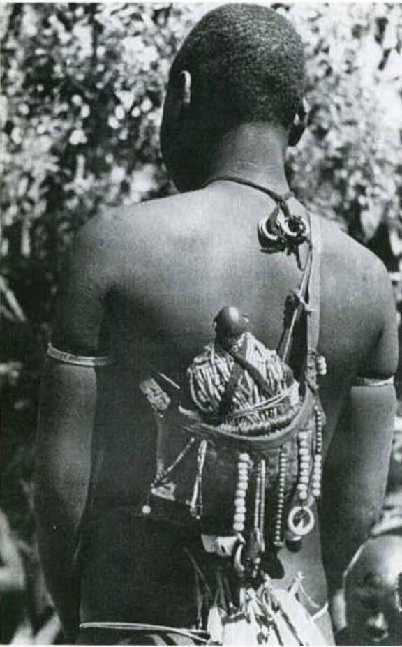 Jeune femme dowayo portant sa poupée de fécondité sur le dos, vers 1941. Photographie d'Alfred Weidholz. Voir KRÜGER Christoph, "Dowayo : Namchi Puppen aus Kamerun Die Dowayo und ihr Kult", Düsseldorf, Verlag U. Gottschalk, 2003.