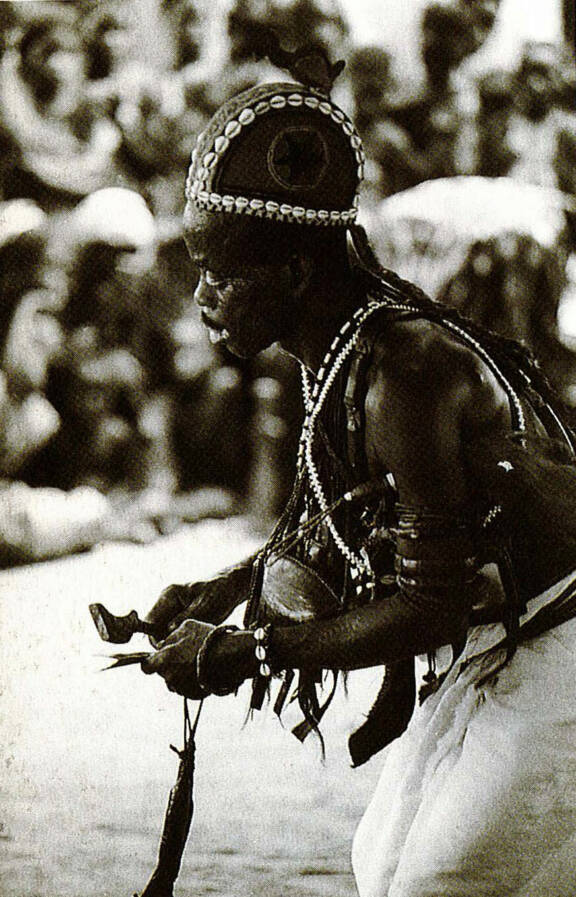 Le devin Kataké frappant son gong avec son marteau lawle au cours d’une cérémonie pour son asie usu, Lolobo, région Nanafwé, 1972 © Susan Mullin Vogel